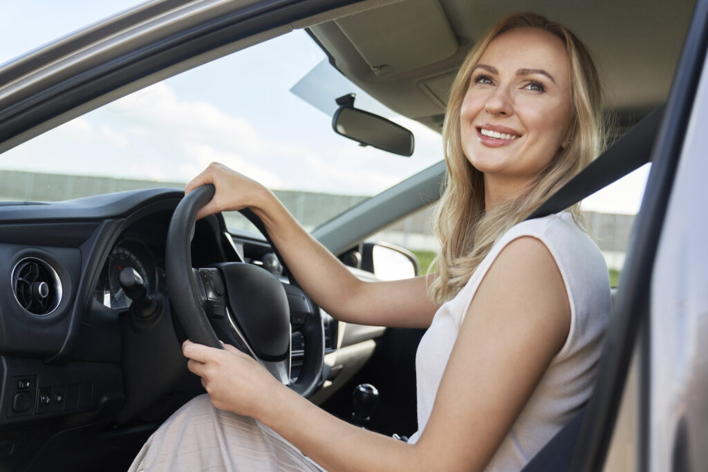 Blonda de la volan, uitându- se la semafor